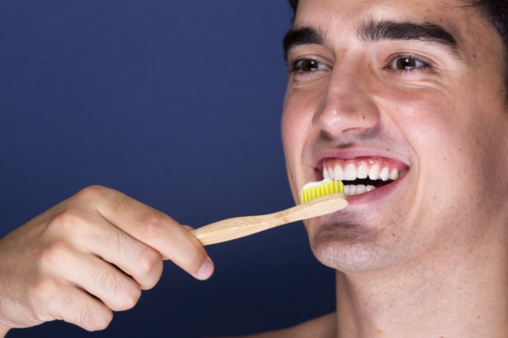 close up adult male using toothbrush 1536x1024