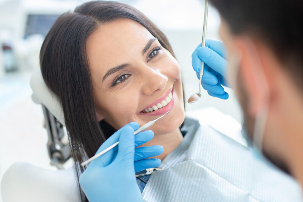 woman smiling at dentist before cleaning 1200x800